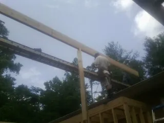 Carpenter setting a ridge beam over a new addition frame — Ice Dam Removal by Roofing Brothers in Marsteller