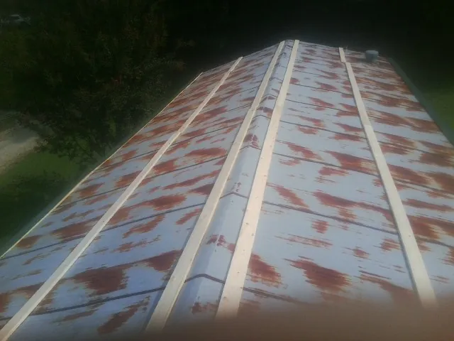 Rusted metal roof panels with new wood purlins before replacement — Storm Damage Roof Repair in Marsteller by Roofing Brothers