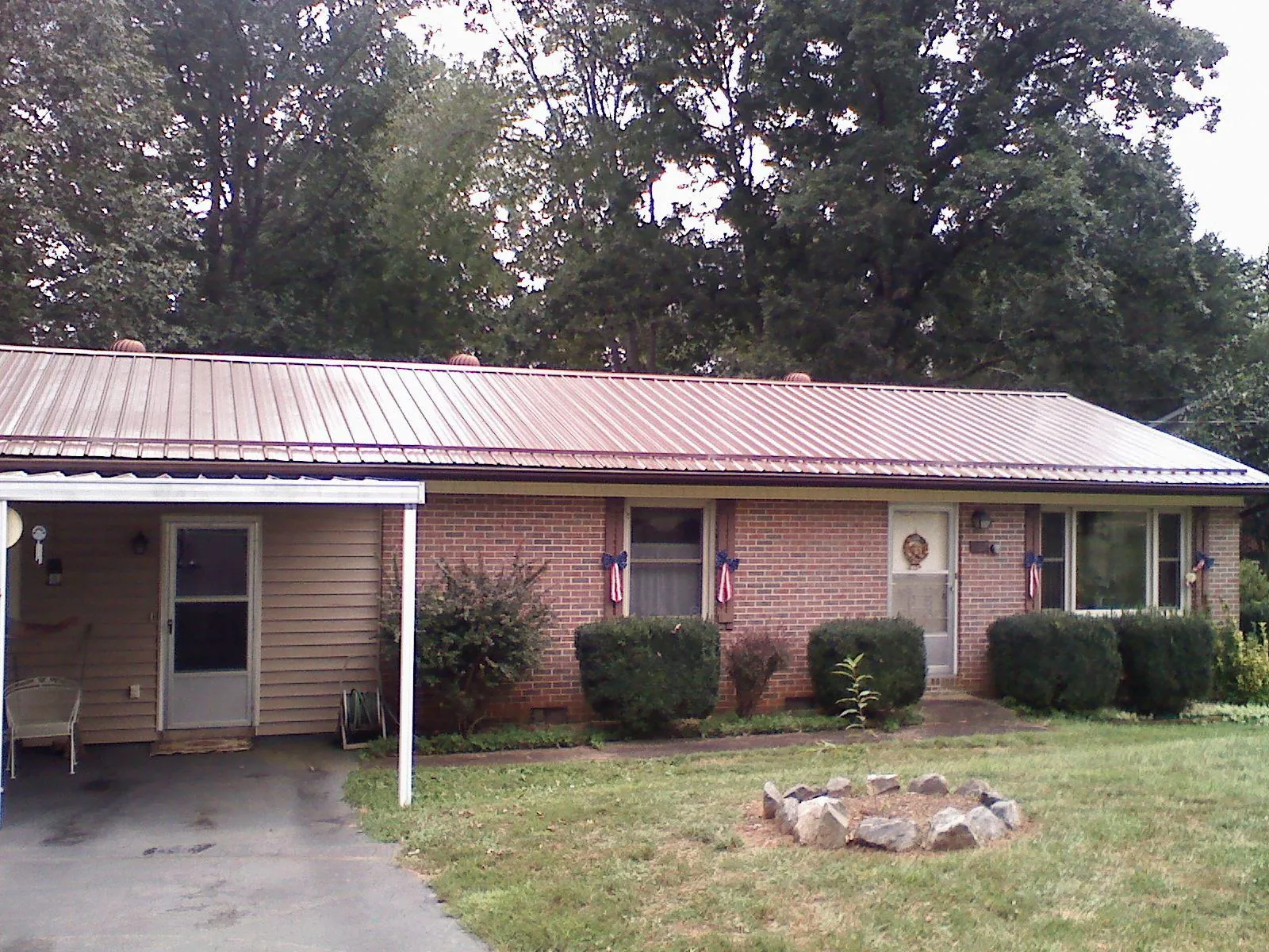 Bronze metal roof and carport on a brick ranch home — Roof Repair work by our crew in Marsteller
